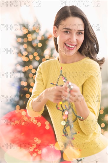 Woman decorating christmas tree.