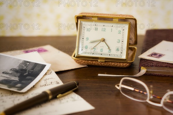 Still life with clock, spectacles and old photos .