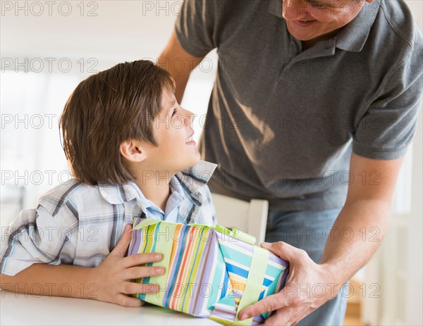 Boy (8-9) receiving gift from father