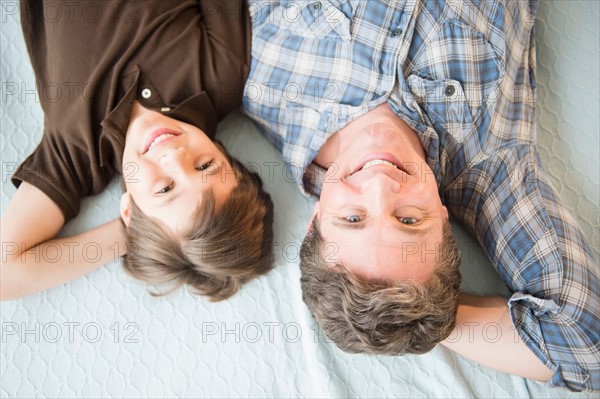 Father and son (8-9) lying on bed