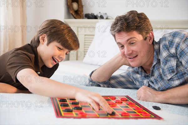 Father and son (8-9) playing checkers