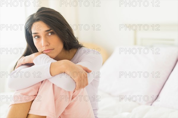 Woman sitting on bed.