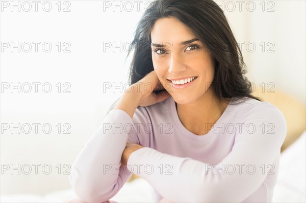 Woman sitting on bed.