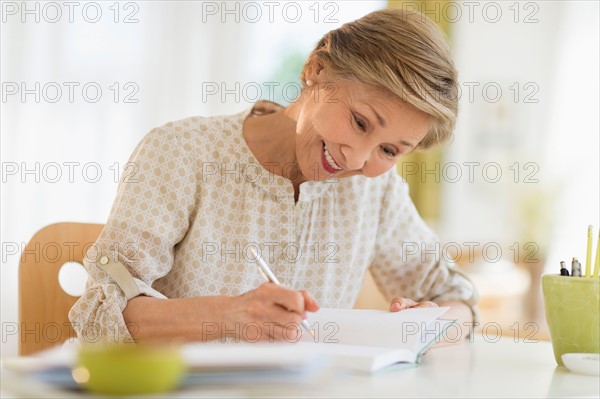 Senior woman writing in diary.
