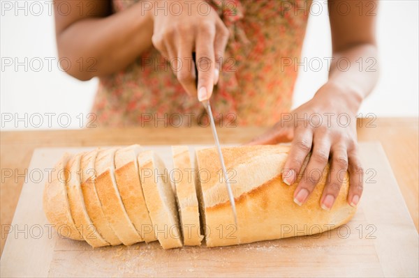 Close up of womaqn's hand cutting bread