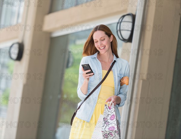 Woman with shopping bags using phone.