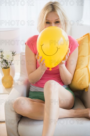 Young woman blowing balloon