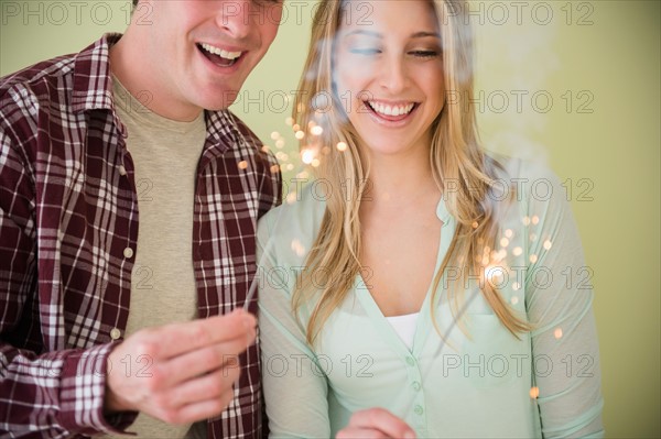 Studio shot of couple holding sparklers