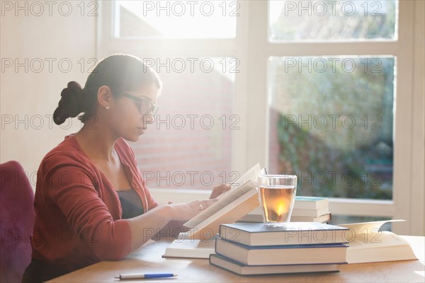 Young woman studying books at desk