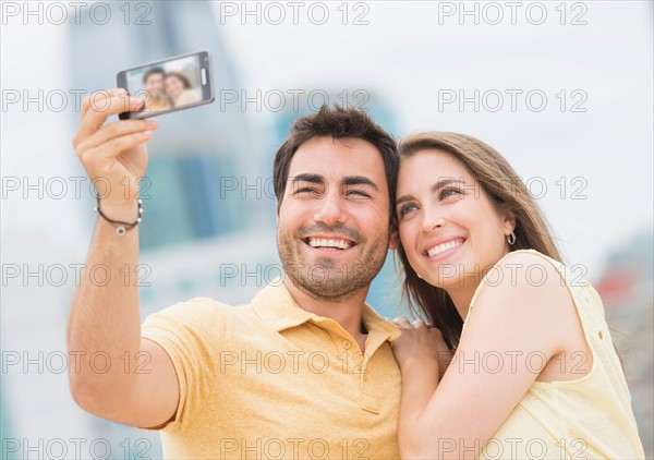 Couple taking self portrait photo with smartphone.