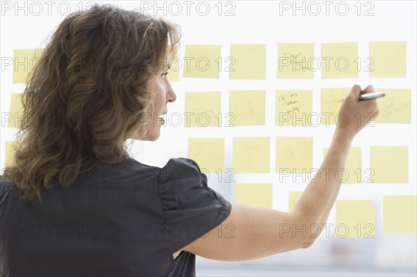 Business woman arranging yellow notes.