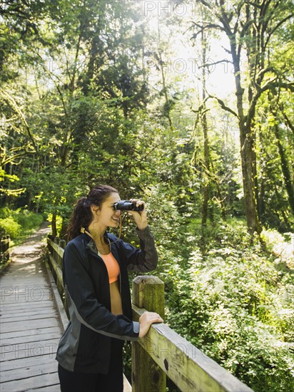 Portrait of woman looking at view with binoculars. USA, Oregon, Portland.