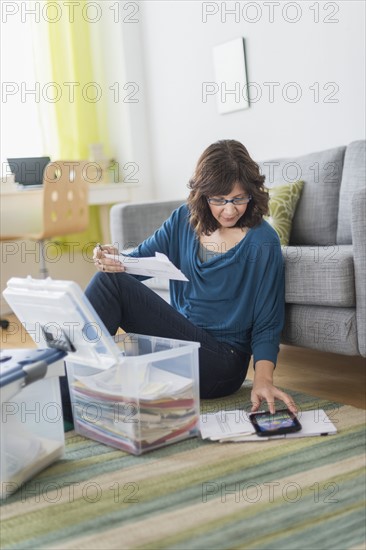 Woman using tablet pc to do paperwork at home.