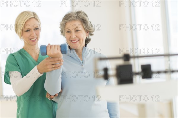 Mature woman exercising with personal trainer.