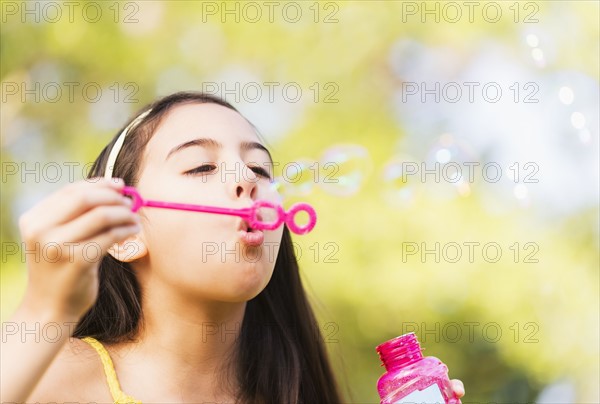 Portrait of girl (8-9) blowing bubbles.
Photo : Daniel Grill