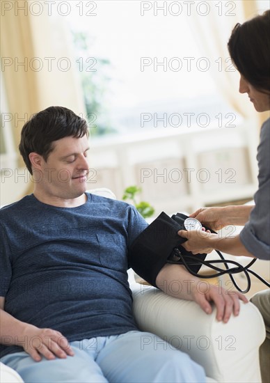 Man with down syndrome having blood pressure measured.