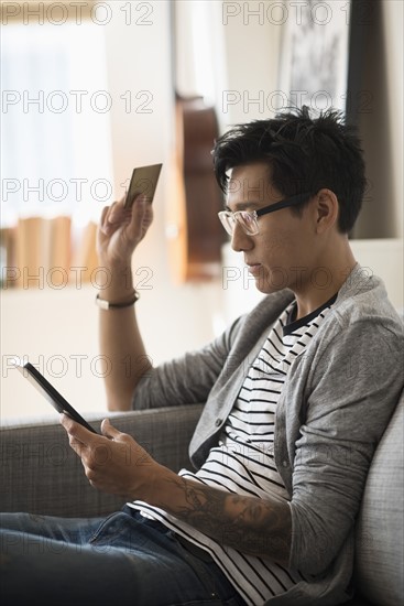 Man paying with credit card on tablet.