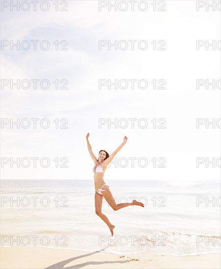 Woman jumping on beach