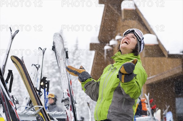 Woman wearing ski googles with hands raised