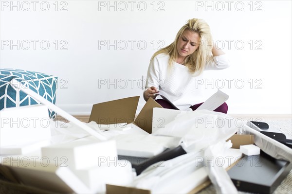 Confused woman reading instruction manual