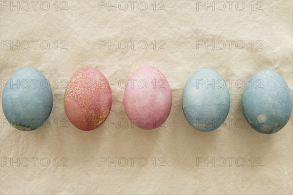 Dyed Easter eggs in a row on beige