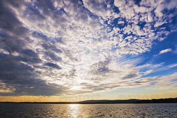 Cloudy sky above bay at sunset