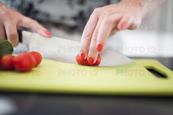 Woman cutting tomatoes on cutting board