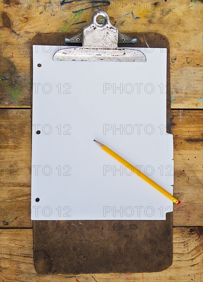 Pencil and clipboard with blank paper