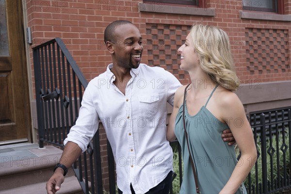 Smiling couple walking in residential district.