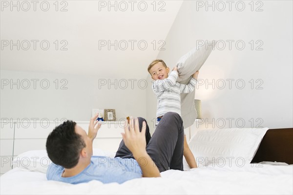 Father and son (4-5) playing in bedroom