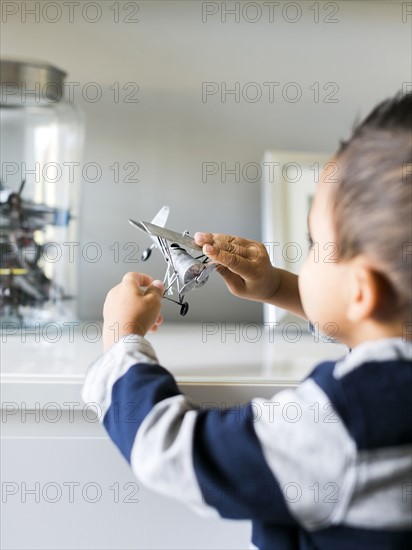 Boy (2-3) playing with model airplane