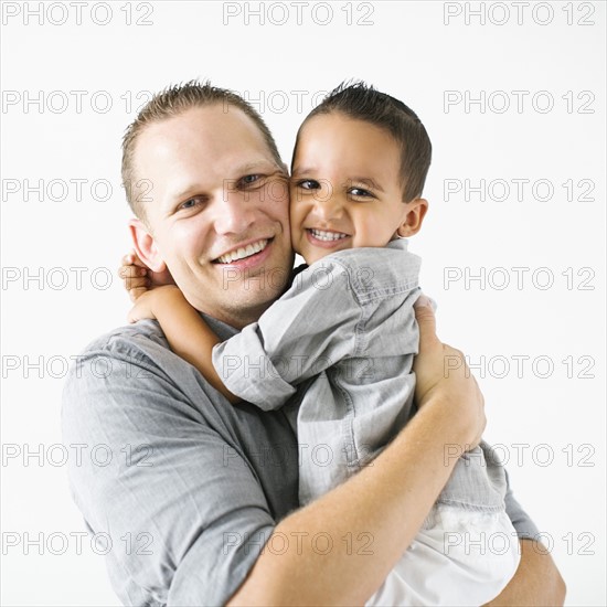Father and son (2-3) embracing and smiling