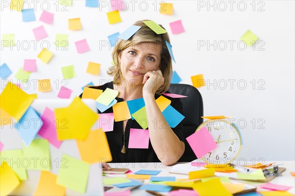 Portrait of Mature woman at office covered with adhesive notes