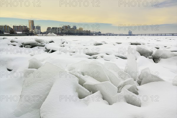 Ukraine, Dnepropetrovsk region, Dnepropetrovsk city, Frozen river with distant cityscape