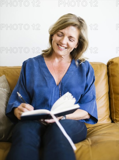 Smiling woman writing in diary