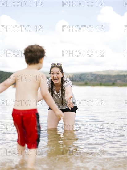 Mother playing with son (4-5) in lake