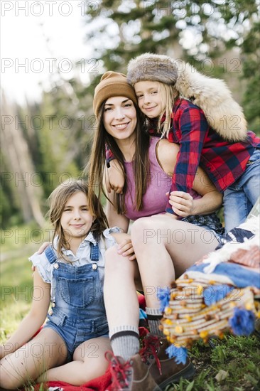 Mother with son (6-7) and daughter (8-9) camping in forest