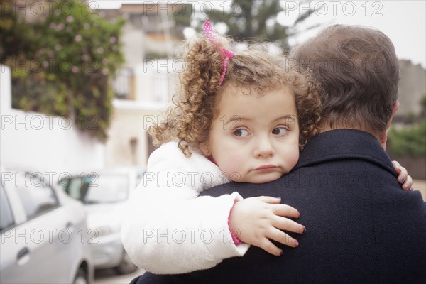 Girl being carried by her father