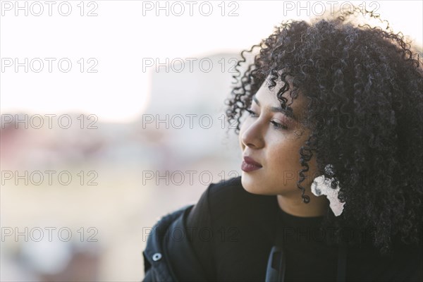 Portrait of young woman with curly black hair