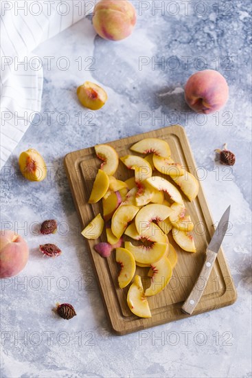 Peaches sliced on wooden cutting board