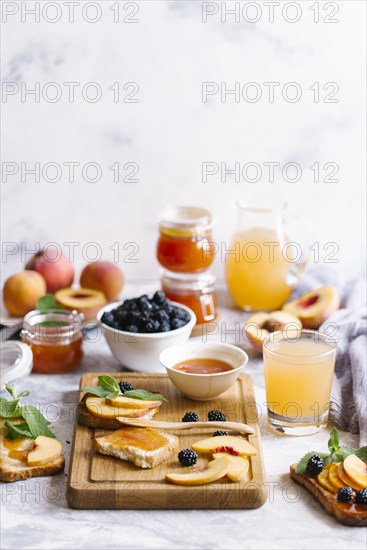 Breakfast spread with blackberries, peaches, toast and apricot jam