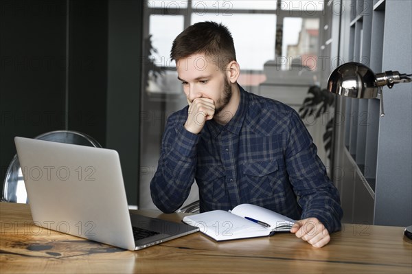 Young businessman looking at laptop