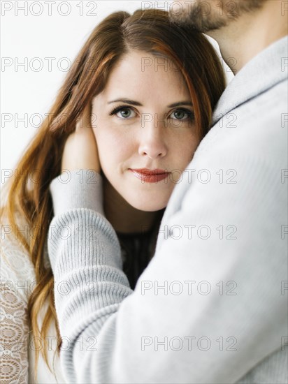 Mid adult woman in man's embrace