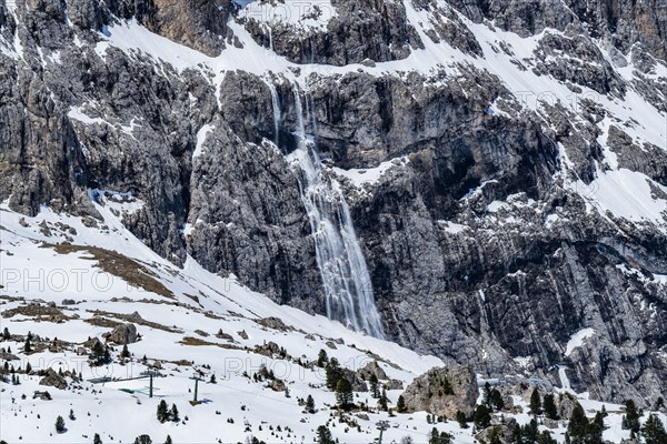 Snow falling down mountain cliff in Dolomites, Italy