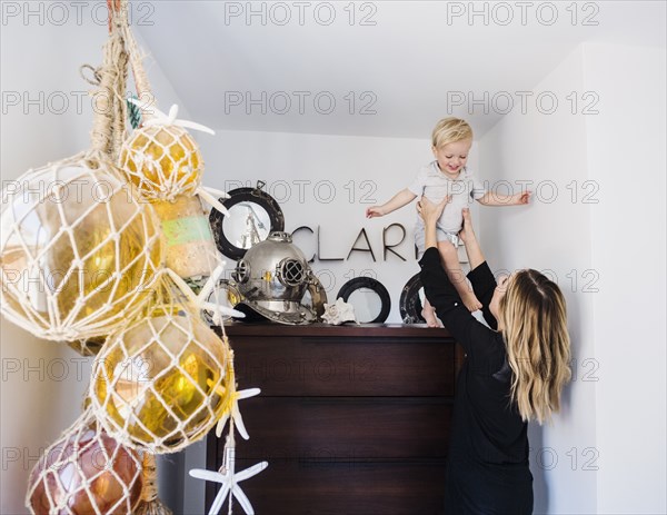 Mother holding son on top of drawers