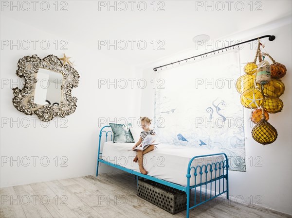 Girl reading book on bed