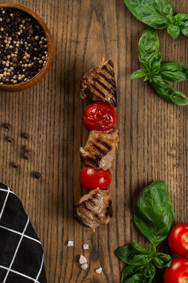 Grilled meat and tomato skewer on cutting board