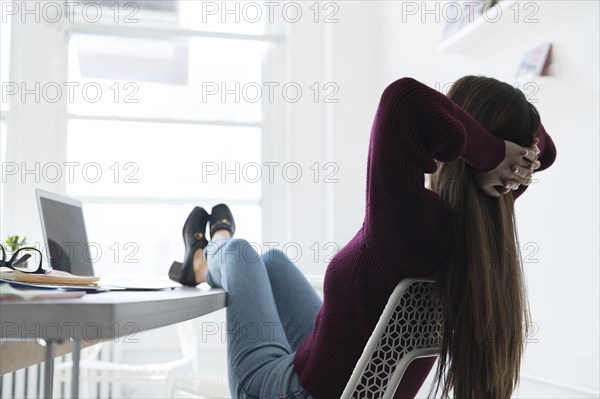 Businesswoman relaxing with feet on office desk