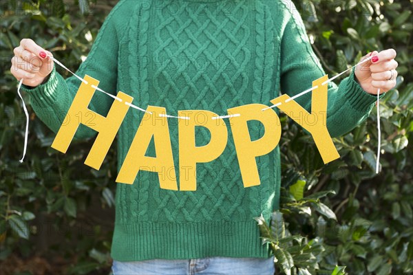 Woman holding 'happy' letters on string