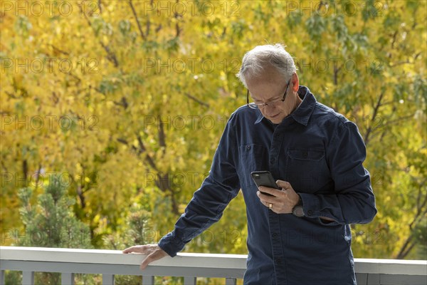 Man using phone by autumn trees